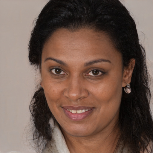 Joyful black adult female with long  brown hair and brown eyes