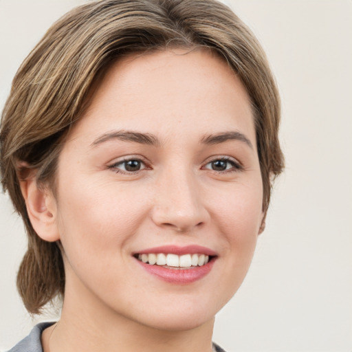 Joyful white young-adult female with medium  brown hair and green eyes