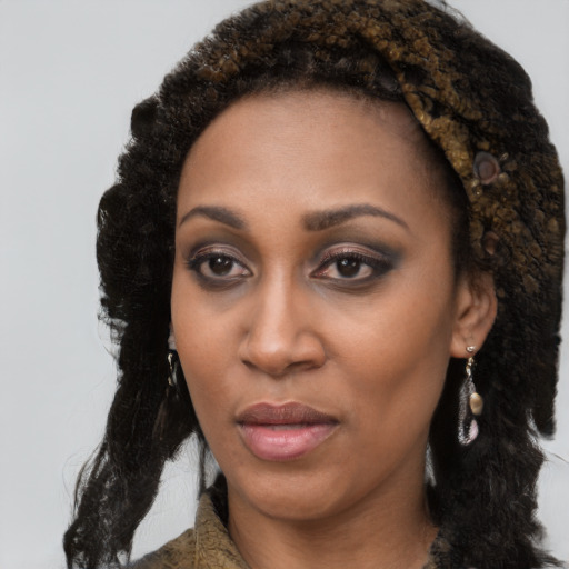 Joyful black young-adult female with long  brown hair and brown eyes