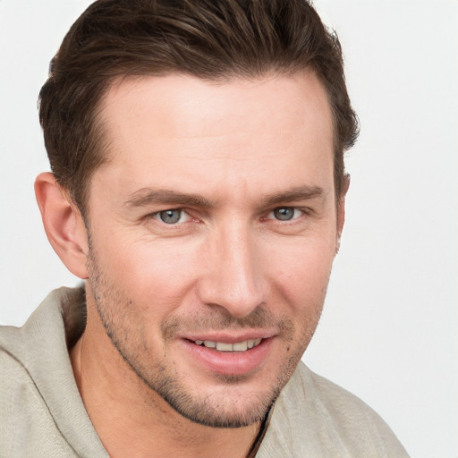 Joyful white young-adult male with short  brown hair and grey eyes