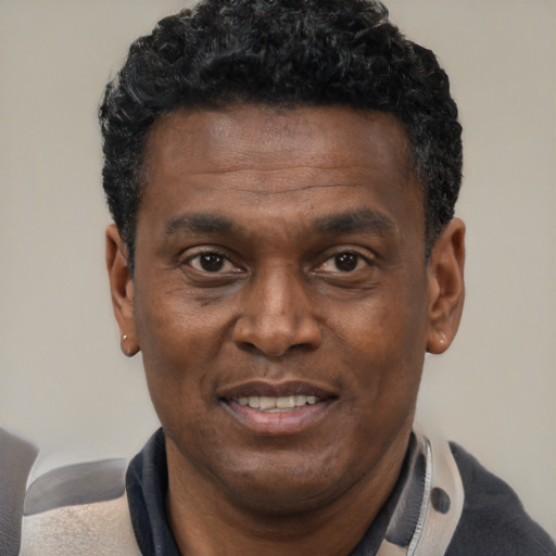 Joyful black young-adult male with short  black hair and brown eyes