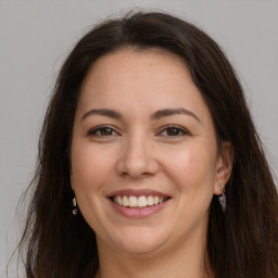 Joyful white adult female with long  brown hair and brown eyes