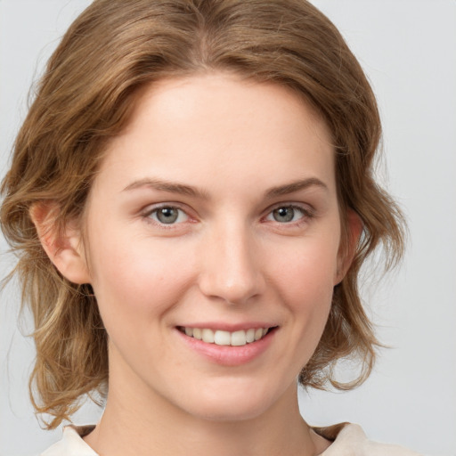 Joyful white young-adult female with medium  brown hair and blue eyes