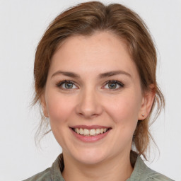 Joyful white young-adult female with medium  brown hair and grey eyes