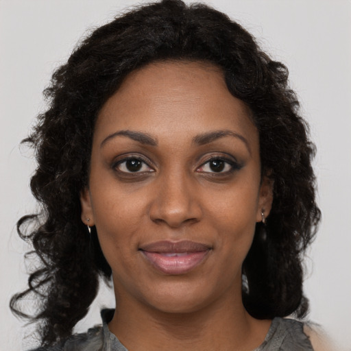 Joyful black adult female with long  brown hair and brown eyes