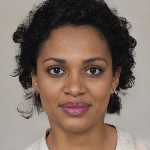 Joyful black young-adult female with medium  brown hair and brown eyes