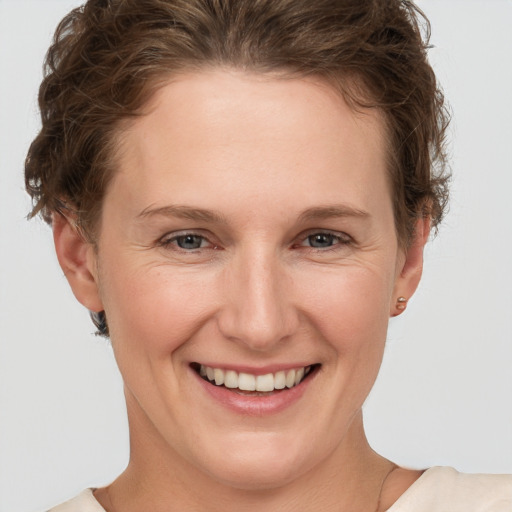 Joyful white young-adult female with short  brown hair and grey eyes