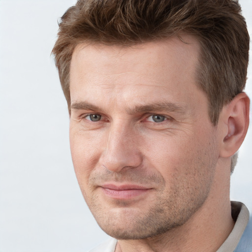 Joyful white adult male with short  brown hair and grey eyes