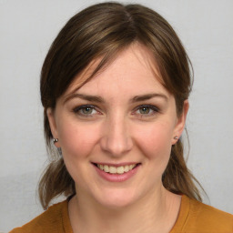 Joyful white young-adult female with medium  brown hair and green eyes