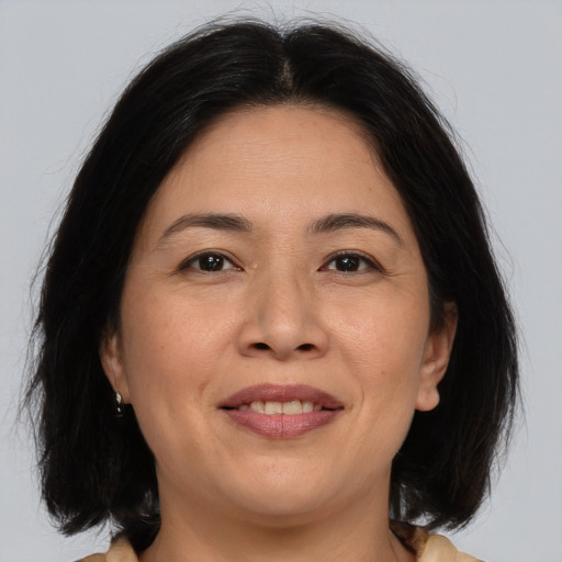 Joyful asian adult female with medium  brown hair and brown eyes