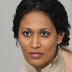 Joyful black adult female with long  brown hair and brown eyes