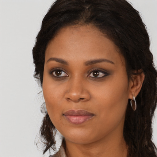 Joyful black young-adult female with long  brown hair and brown eyes