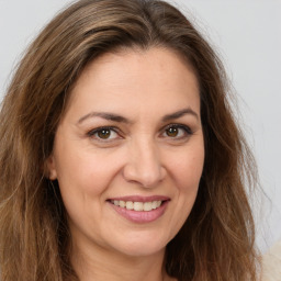 Joyful white adult female with long  brown hair and brown eyes