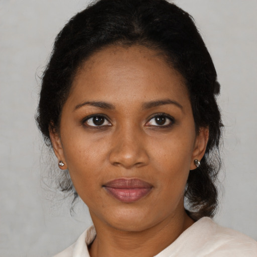 Joyful black adult female with medium  black hair and brown eyes