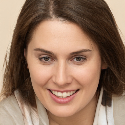 Joyful white young-adult female with long  brown hair and brown eyes