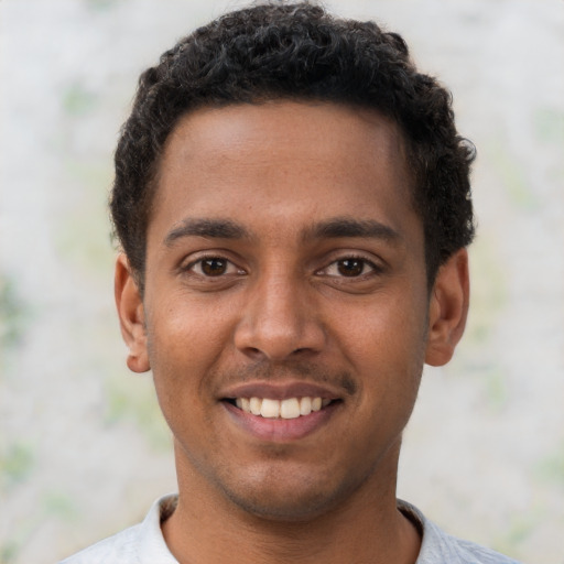 Joyful black young-adult male with short  brown hair and brown eyes