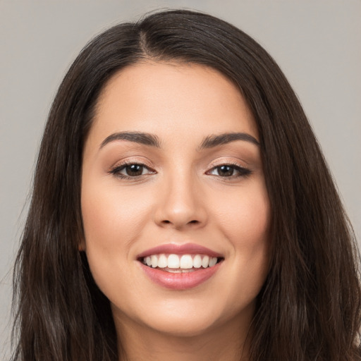 Joyful white young-adult female with long  brown hair and brown eyes