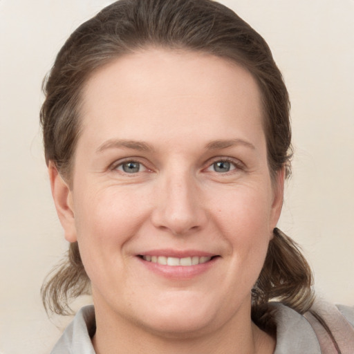 Joyful white young-adult female with medium  brown hair and grey eyes