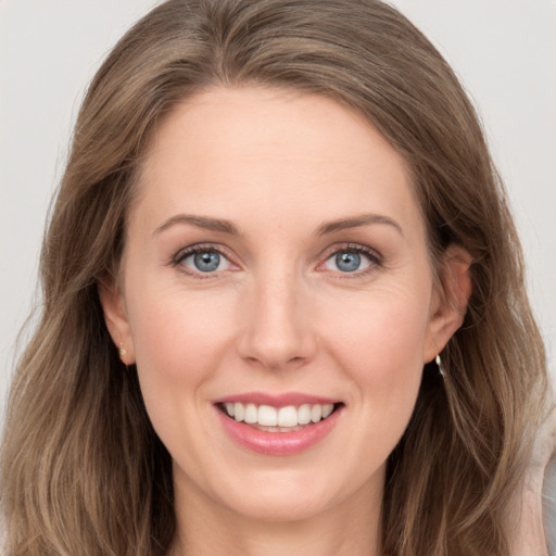 Joyful white young-adult female with long  brown hair and grey eyes