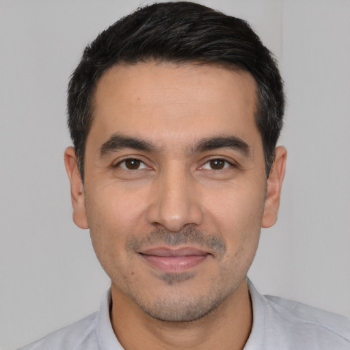 Joyful white young-adult male with short  black hair and brown eyes