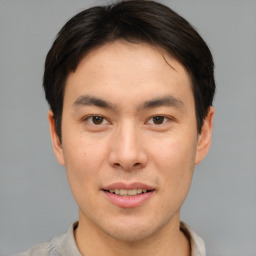 Joyful asian young-adult male with short  brown hair and brown eyes