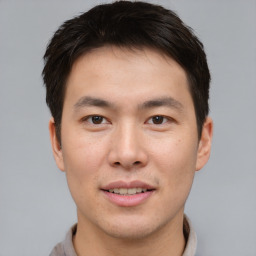 Joyful asian young-adult male with short  brown hair and brown eyes