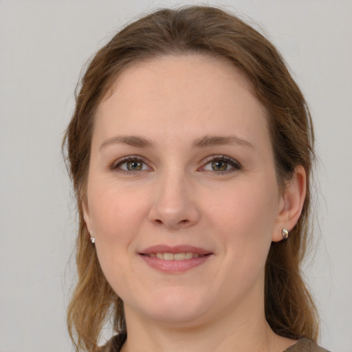 Joyful white young-adult female with medium  brown hair and grey eyes