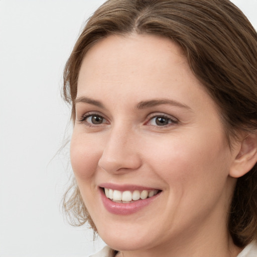 Joyful white young-adult female with medium  brown hair and grey eyes