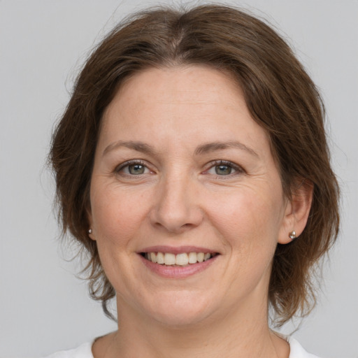 Joyful white adult female with medium  brown hair and grey eyes