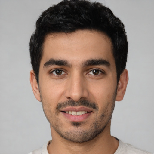 Joyful white young-adult male with short  black hair and brown eyes