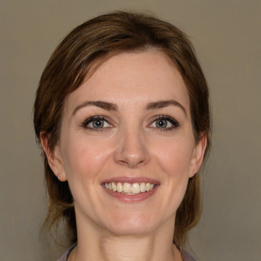 Joyful white young-adult female with medium  brown hair and grey eyes