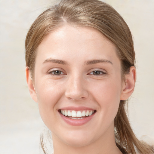 Joyful white young-adult female with long  brown hair and blue eyes