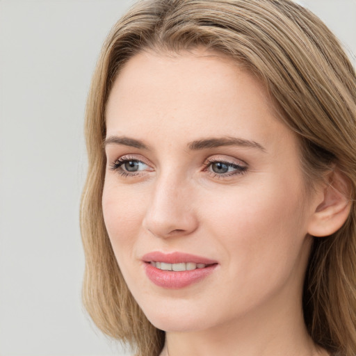 Joyful white young-adult female with long  brown hair and blue eyes