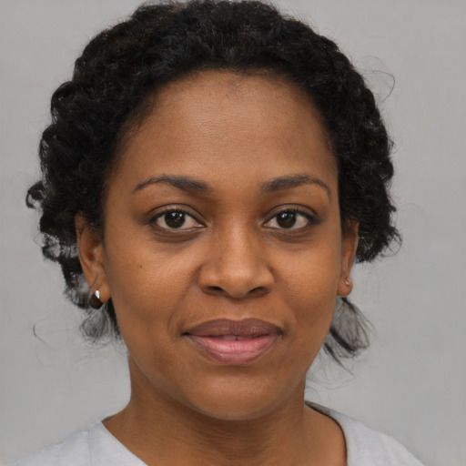 Joyful black young-adult female with medium  brown hair and brown eyes