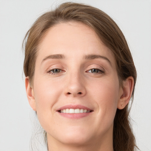 Joyful white young-adult female with long  brown hair and grey eyes