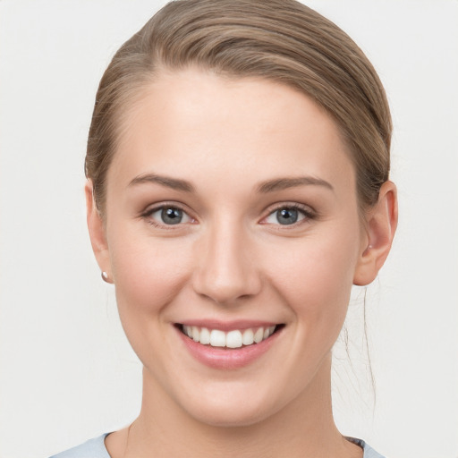 Joyful white young-adult female with short  brown hair and grey eyes