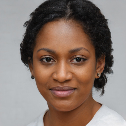 Joyful black young-adult female with medium  black hair and brown eyes