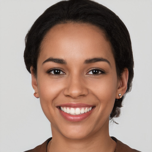 Joyful latino young-adult female with short  black hair and brown eyes