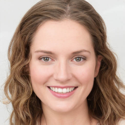 Joyful white young-adult female with long  brown hair and green eyes