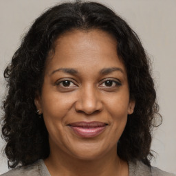 Joyful black adult female with medium  brown hair and brown eyes