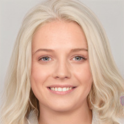 Joyful white young-adult female with long  blond hair and blue eyes