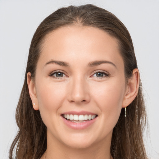 Joyful white young-adult female with long  brown hair and grey eyes