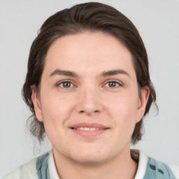 Joyful white young-adult female with medium  brown hair and grey eyes