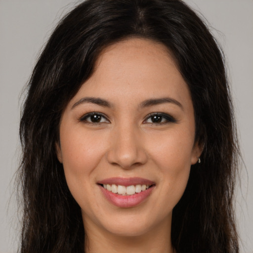 Joyful latino young-adult female with long  brown hair and brown eyes