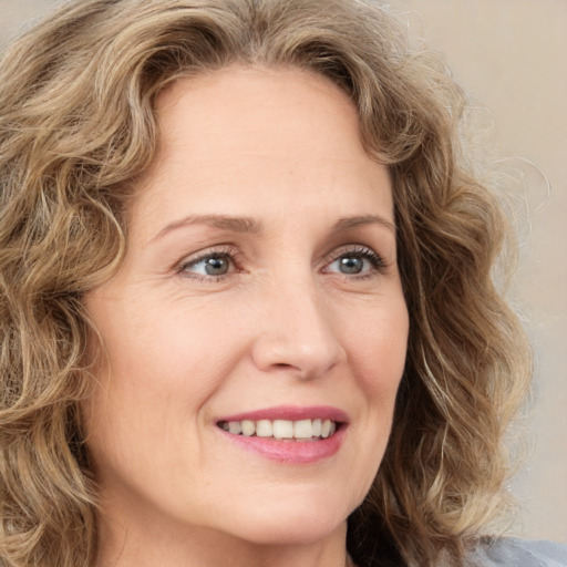 Joyful white adult female with medium  brown hair and green eyes