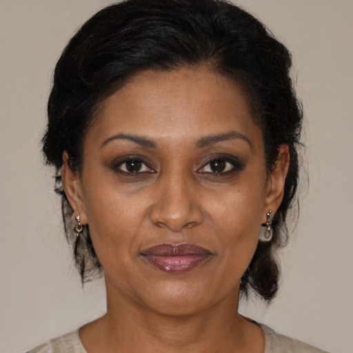 Joyful black adult female with medium  brown hair and brown eyes