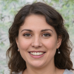 Joyful white young-adult female with medium  brown hair and green eyes