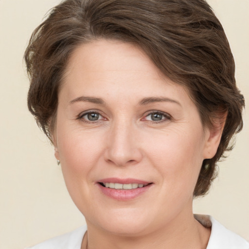 Joyful white young-adult female with medium  brown hair and grey eyes