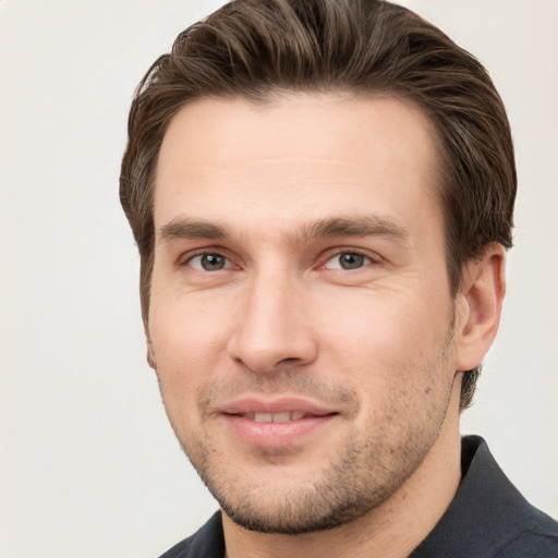 Joyful white young-adult male with short  brown hair and grey eyes