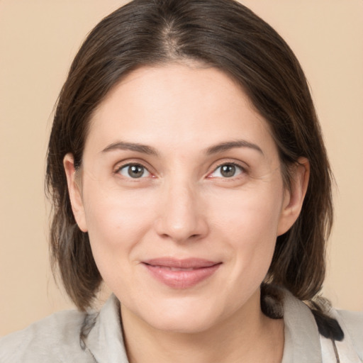 Joyful white young-adult female with medium  brown hair and grey eyes